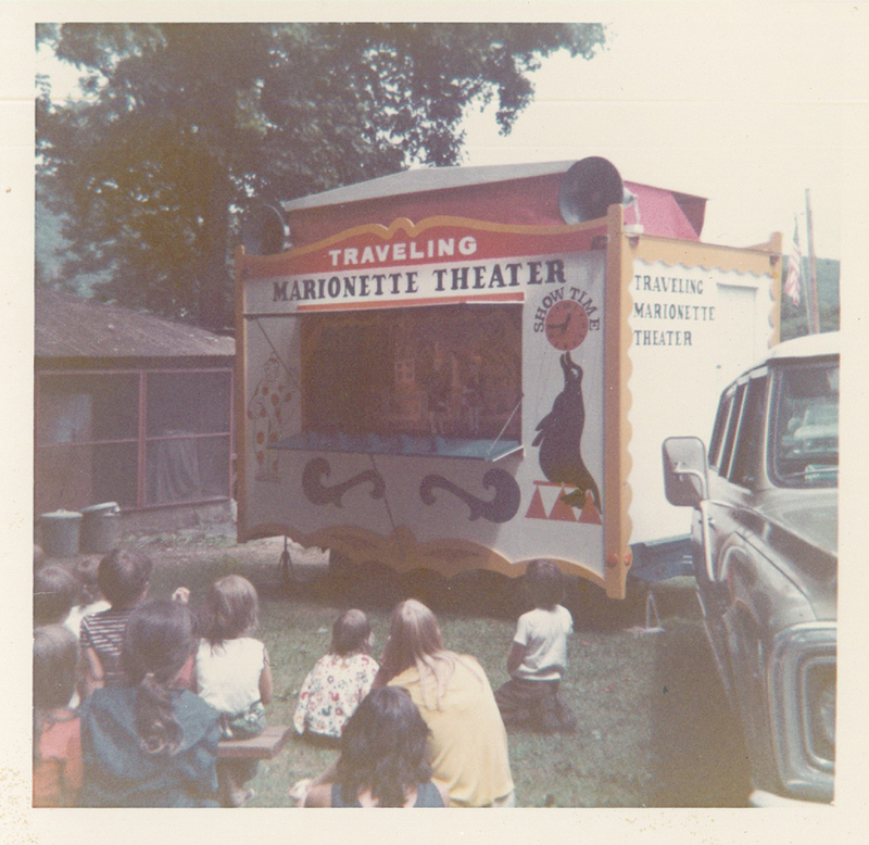 Several children watching a puppet show.