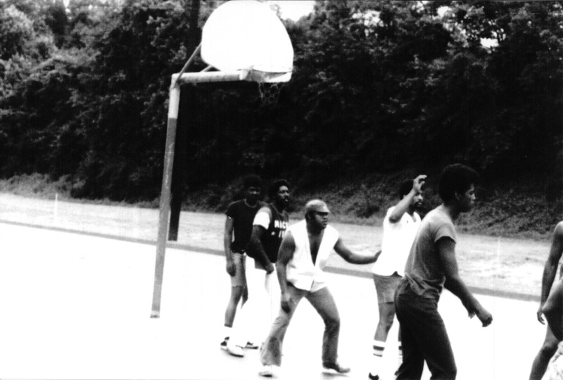 A group of men playing basketball on the playground.