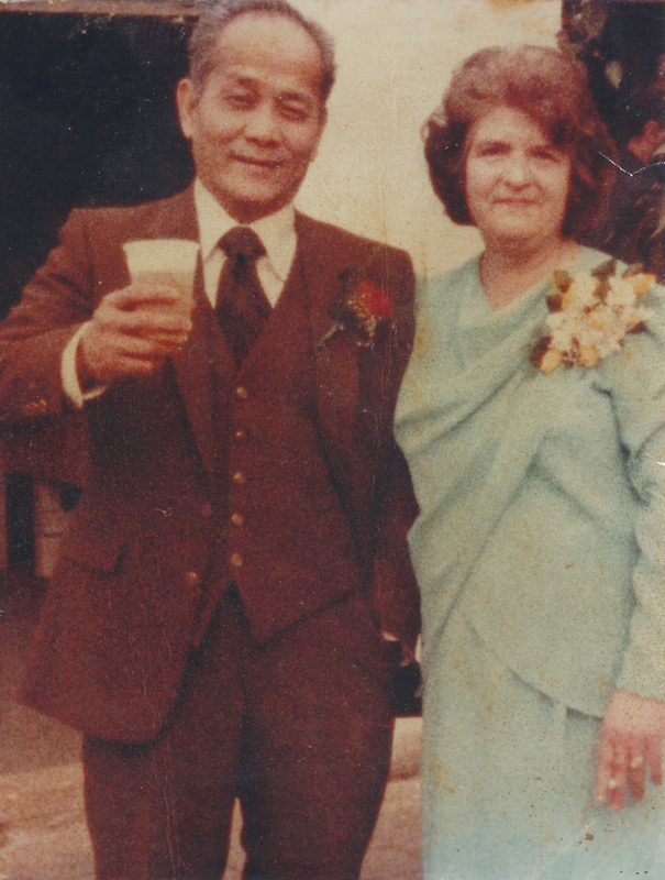 A man in a suit standing next to a woman in a light blue dress.