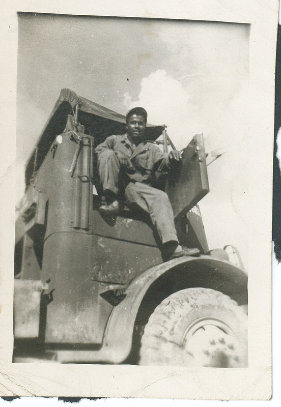 A man sitting in a truck with the door open.