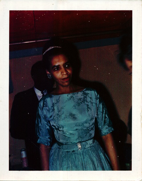 A woman wearing a blue holiday dress and tiara.