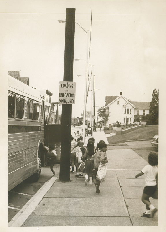 Several children boarding a bus.