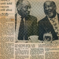 Newspaper clipping featuring two men in professional attires speaking to each other on a social event.