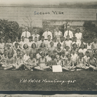 Several children sitting on grass in rows.