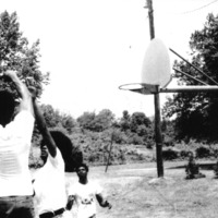 A group of men play basketball on the playground.