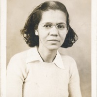 A headshot of a woman wearing glasses and sweater.
