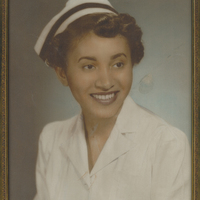 A smiling woman in a nurse uniform.